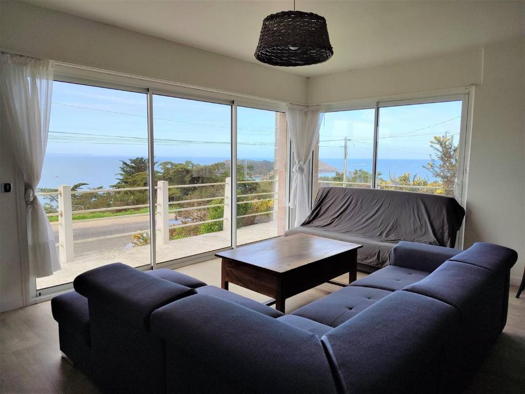 un salon avec un canapé bleu et une table dans l'établissement Maison avec jardin clos à 800m de la plage à Trébeurden - FR-1-368-335, à Trébeurden