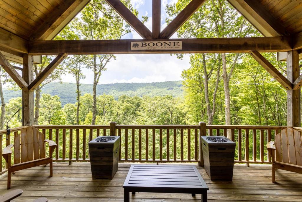 a screened in porch with chairs and a sign that reads bourbon at The Ponderosa in Boone