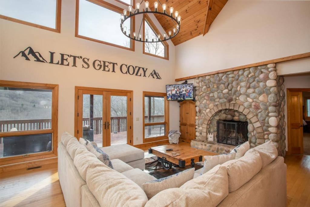 a living room with couches and a stone fireplace at Villa Costalotta in Sugar Mountain