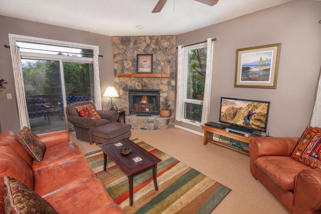 un soggiorno con divano e camino di Yonahlossee Getaway a Boone