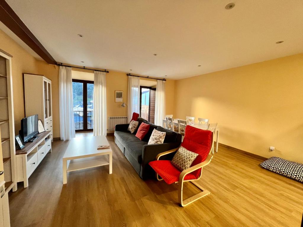 a living room with a couch and a red chair at Tu&Mi Villafranca in Villafranca del Bierzo