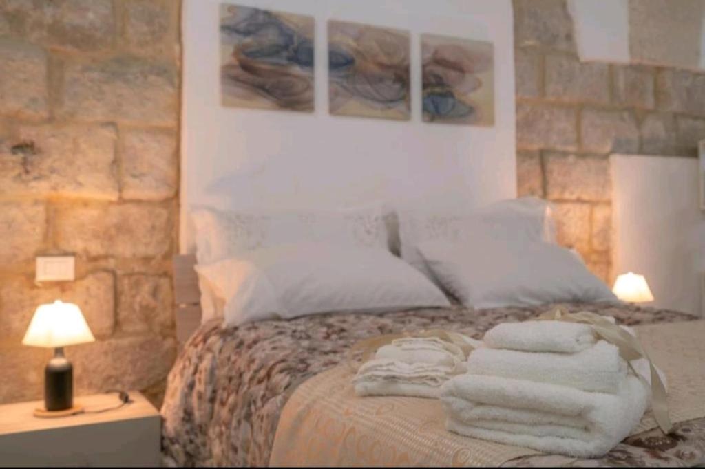 a bedroom with a bed with towels on it at LA CASA DEI CANDELAI in Siracusa