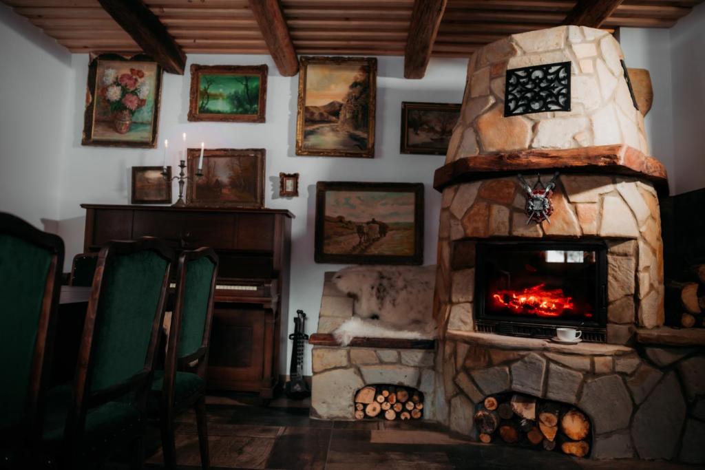 una sala de estar con chimenea de piedra. en Huta Village, en Piatra