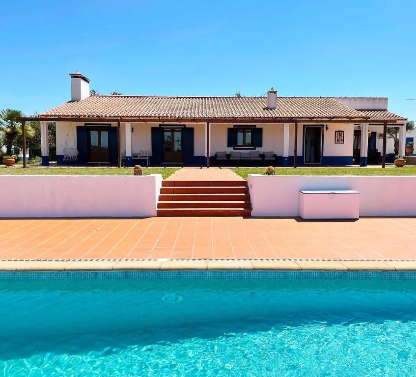 una casa con piscina frente a una casa en Monte do Poejo, 