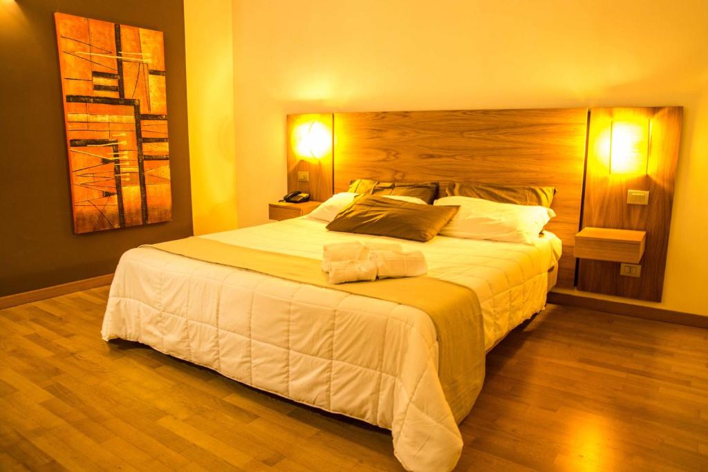 una camera da letto con un grande letto bianco con due lampade di Country House Corte Del Sole a Campolungo