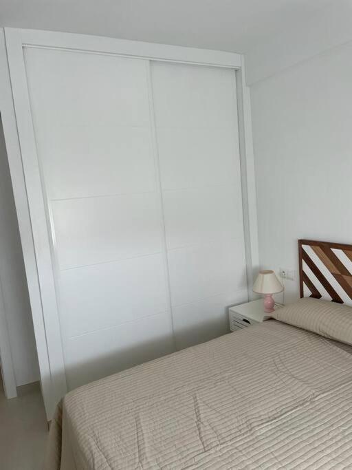 sypialnia z łóżkiem i dużym oknem w obiekcie Reformado con vistas al mar w mieście Nerja