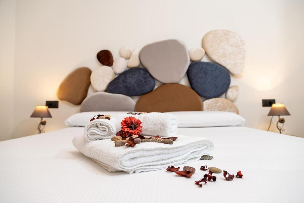 a white bed with towels and flowers on it at Amaltea in San Severino