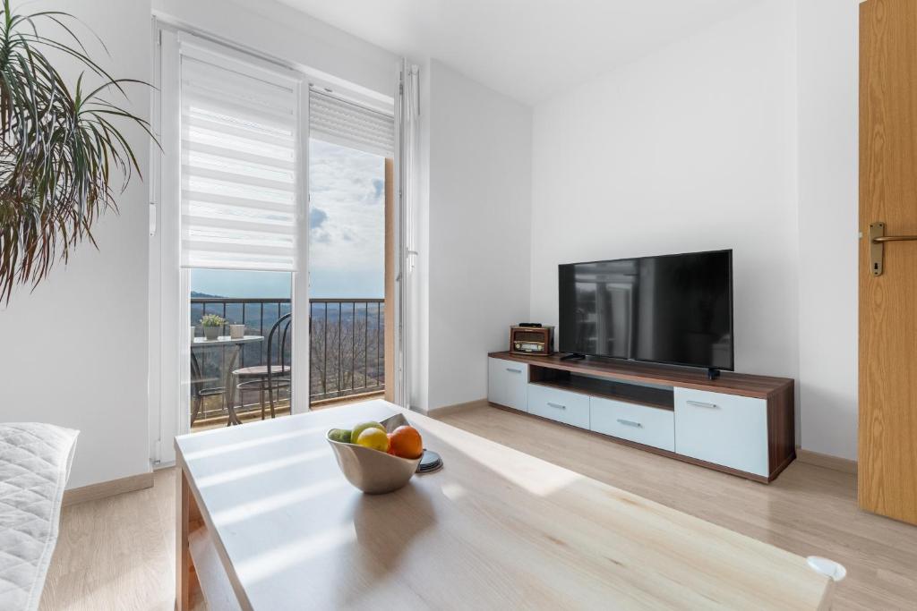 una sala de estar con TV y un plato de fruta en una mesa. en Apartment MDM, en Buje