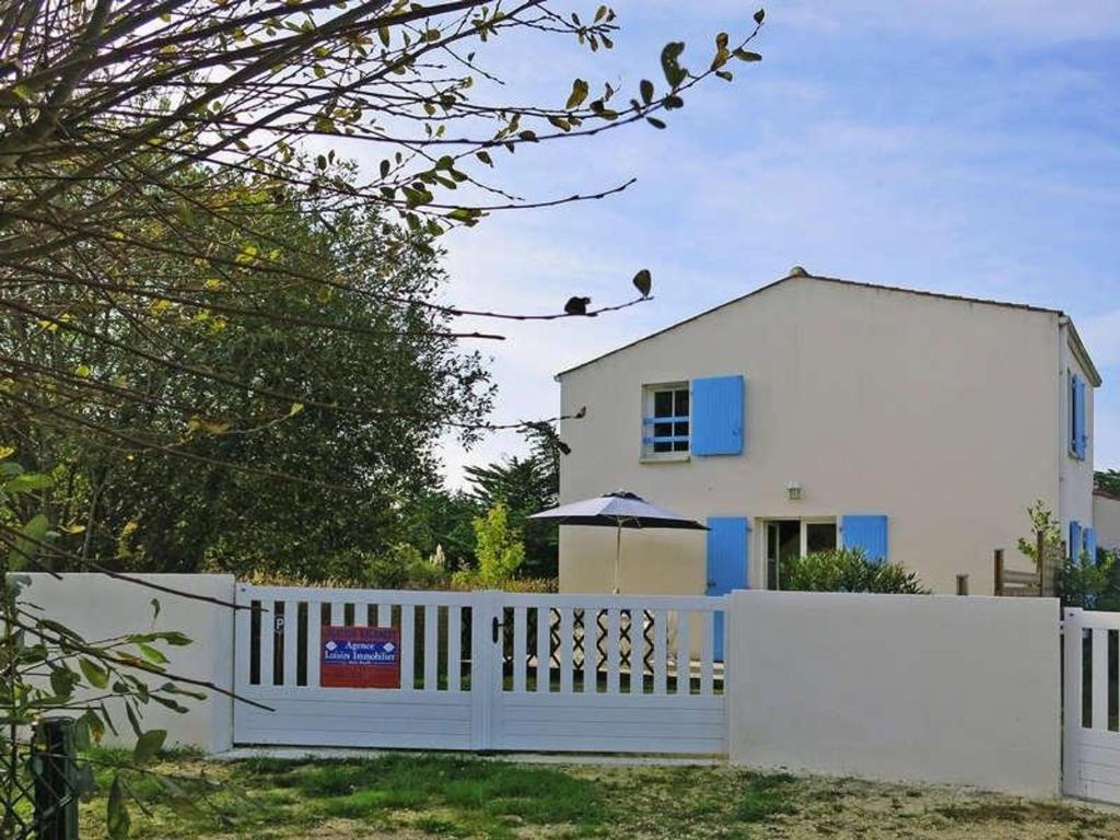 une maison blanche avec une porte blanche et une clôture dans l'établissement Maison de vacances calme à St-Georges-d'Oléron, proche plage, 4 couchages, jardin, parking, ménage inclus - FR-1-246A-204, à Saint-Georges-dʼOléron