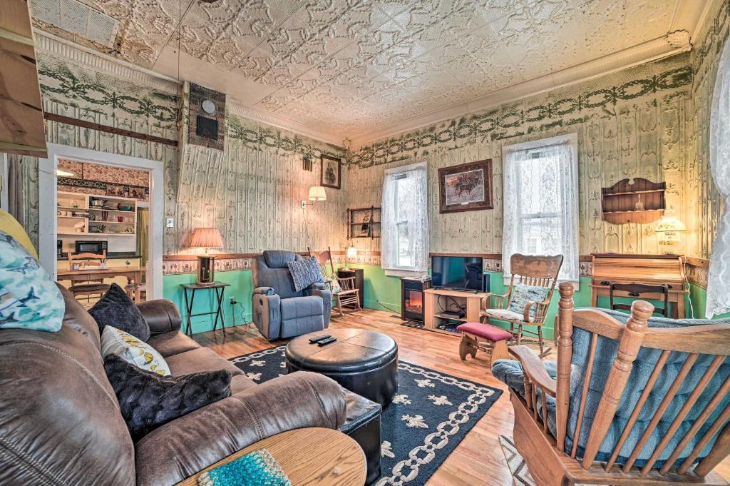 a living room with a couch and a table at Historic Houghton Lake Getaway Near Shoreline in Houghton Lake
