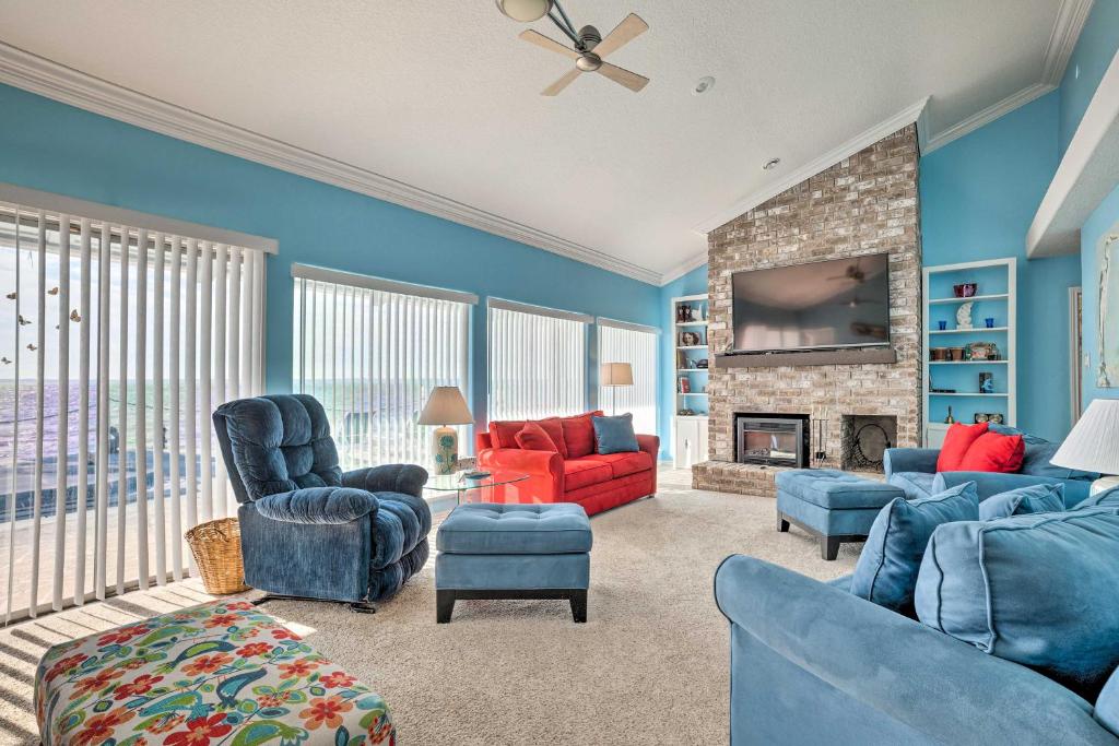 a living room with blue furniture and a fireplace at Lakefront Livingston Home with Grill and Views! in Blanchard