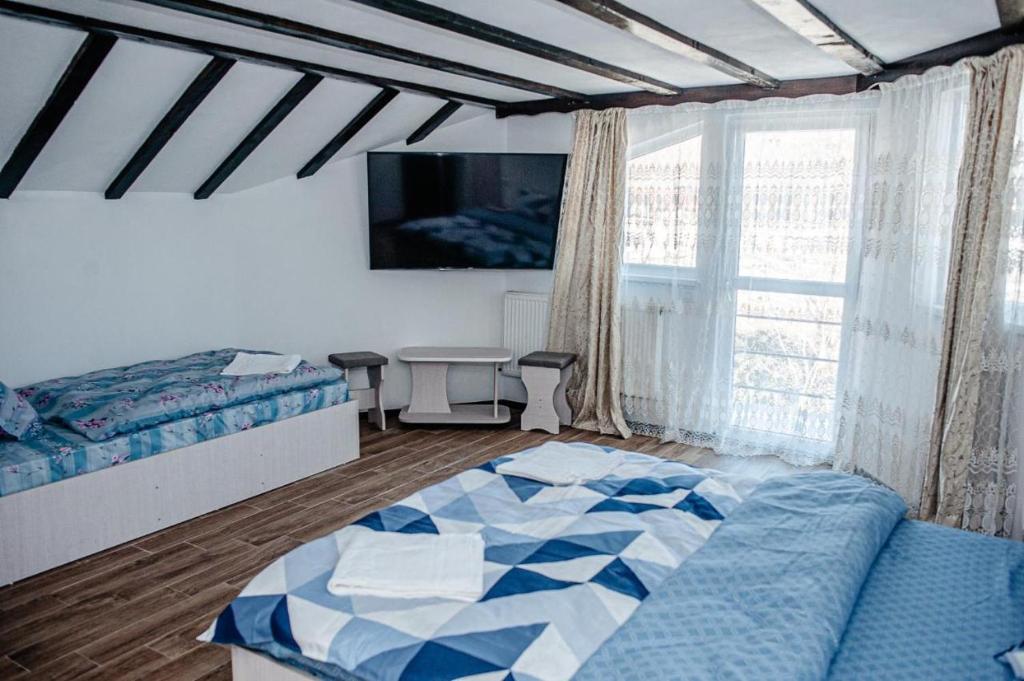 um quarto com uma cama e uma grande janela em LaBebe - Vidraru em Arefu