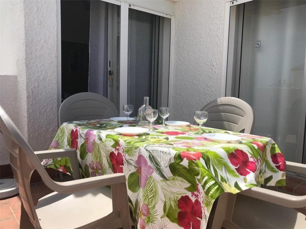 - une table avec une toile de table et des verres à vin dans l'établissement Appartement T2 à 150m de la plage, 5 couchages, terrasse, parking, proche commerces - Port Leucate - FR-1-81-71, à Port-Leucate