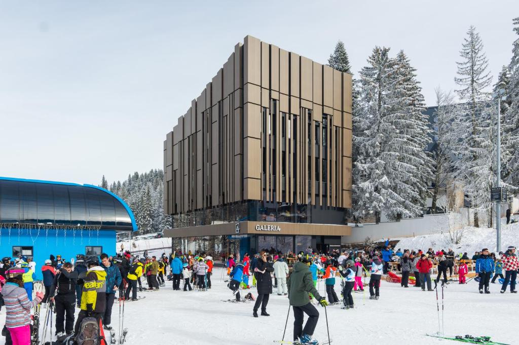 a crowd of people standing outside of a ski lodge at Galeria Jahorina Luxury Ski Apartments and Restaurant in Jahorina