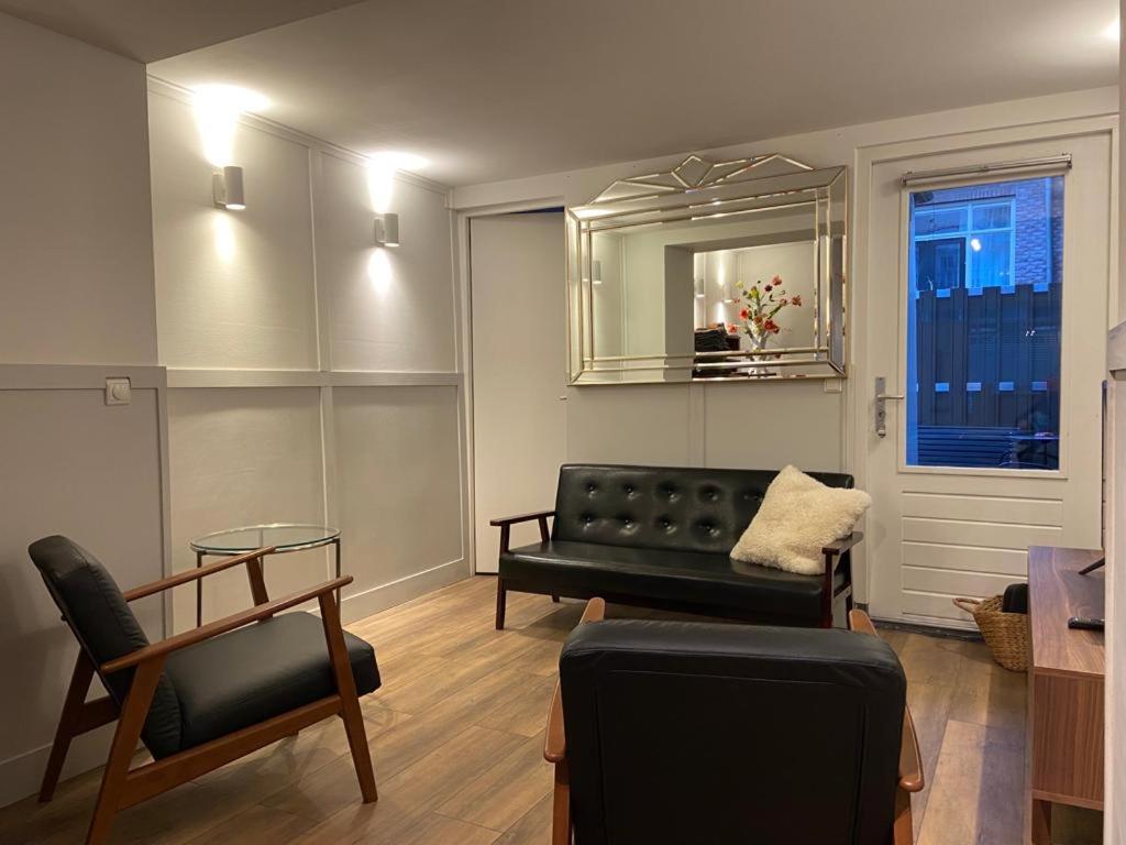 阿姆斯特丹的住宿－Jordaanapartment，客厅配有黑色沙发和镜子