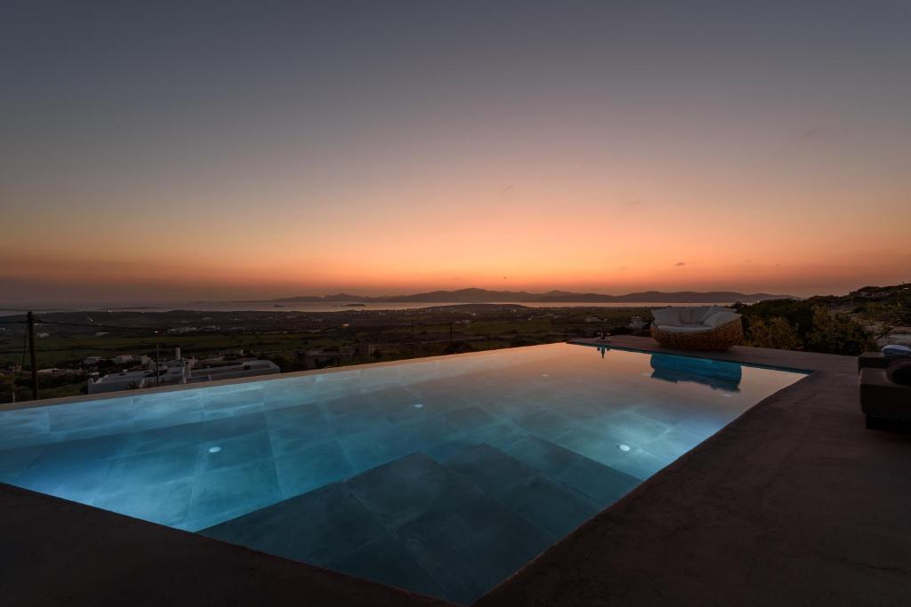 a swimming pool with a sunset in the background at Villa Sunset in Aliki