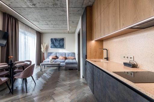 a kitchen and living room with a couch in the background at Pajūrio Oazė MG13 in Klaipėda