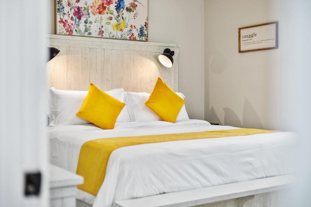 1 dormitorio con cama blanca y almohadas amarillas en The Happy Place: 3BR Home on Quiet Street, en Douglasville