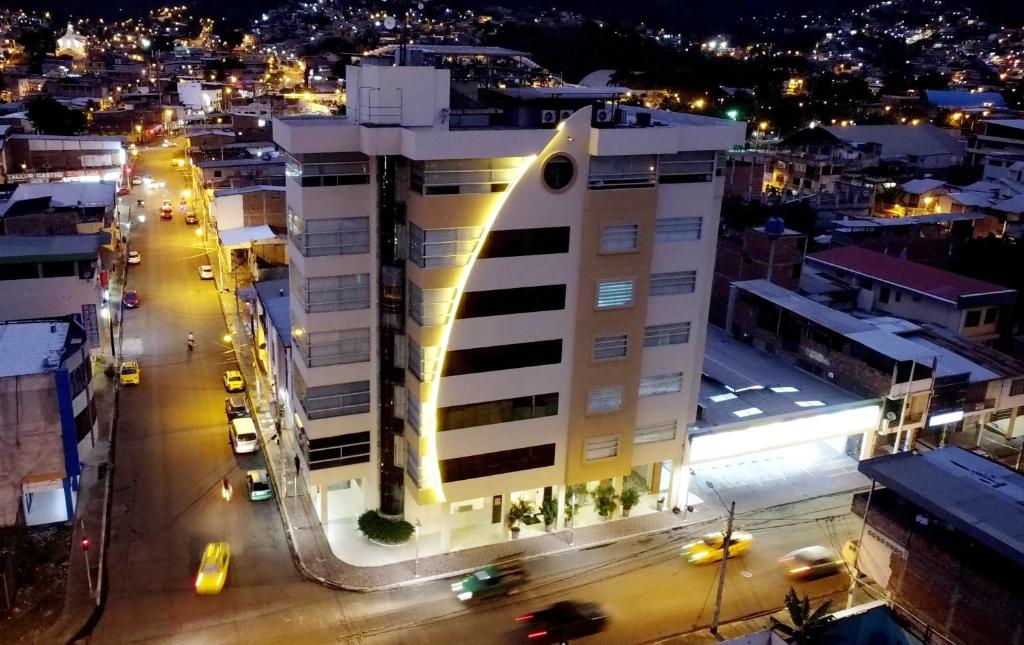 uma cidade à noite com um edifício branco em Hotel Ceibo Dorado em Portoviejo