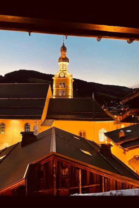 a building with a clock tower on top of it at Romy appartement centre village in Megève