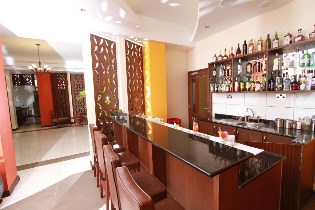 a bar in a restaurant with a counter and chairs at Hotel Rio in Nairobi