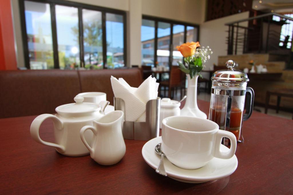 a table with white cups and saucers on it at Hotel Rio in Nairobi
