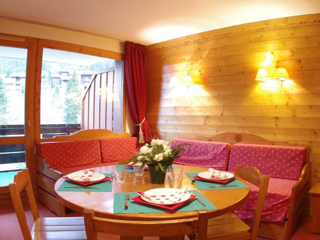 a dining room with a table and a couch at Appartement Valmorel, 3 pièces, 6 personnes - FR-1-291-765 in Valmorel