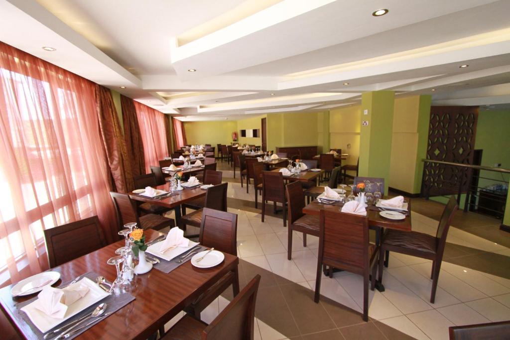 a dining room with tables and chairs in a restaurant at Hotel Rio in Nairobi