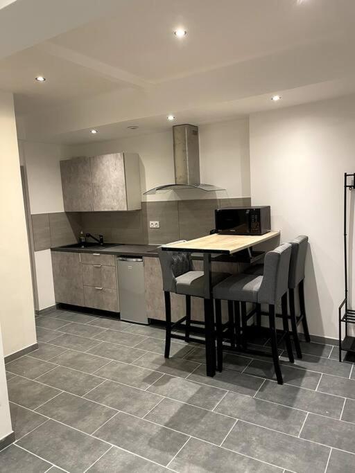 une cuisine avec une table et des chaises dans une pièce dans l'établissement Jolie T2 au coeur des collines, à Les Veyrières