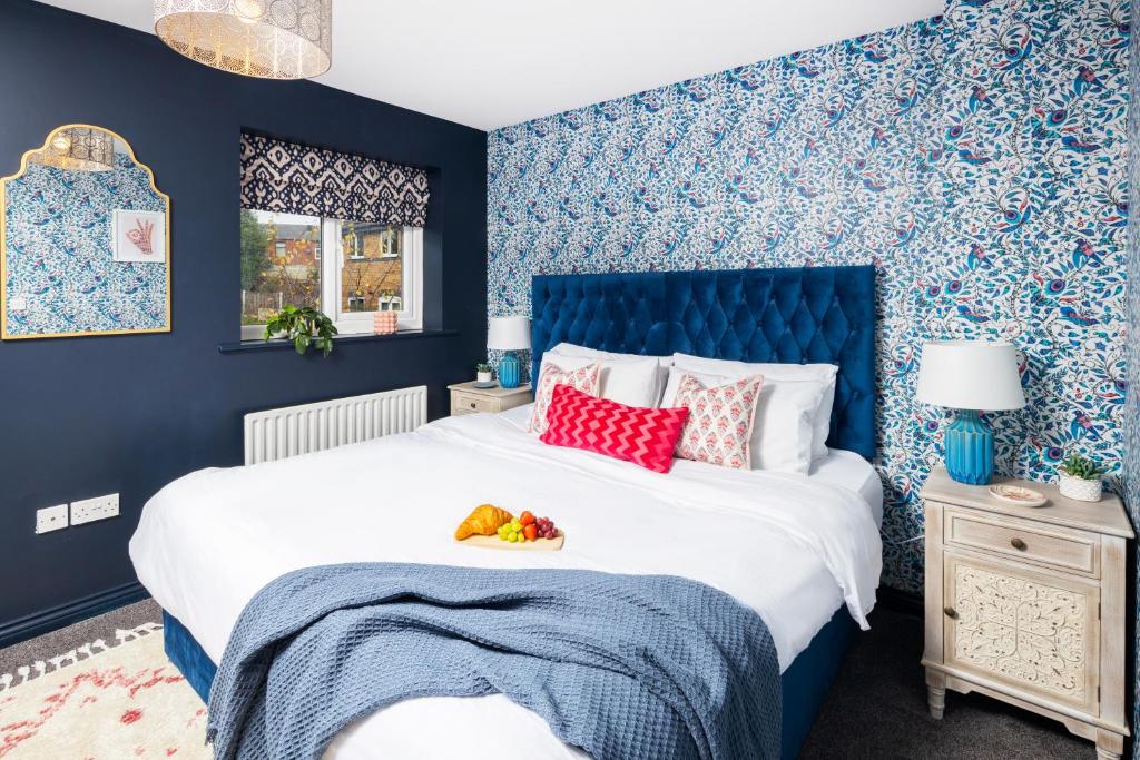 a bedroom with blue walls and a bed with a blue headboard at Whiteoak House in Bolton