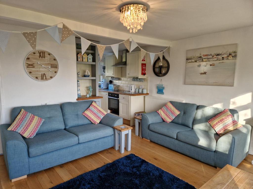 ein Wohnzimmer mit 2 blauen Sofas und einer Küche in der Unterkunft Caldon Holiday Chalet sleeps 4 in Dartmouth WIFI Electric inc Pet friendly in Dartmouth