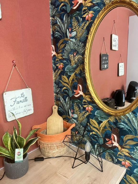 um espelho numa parede ao lado de uma mesa com plantas em T1 bis avec piscine em Canet-en-Roussillon