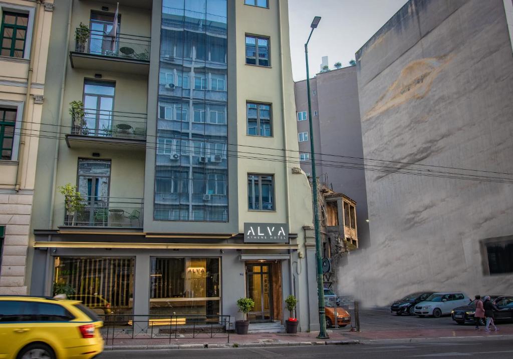 un coche amarillo estacionado frente a un edificio alto en Alva Athens Hotel, en Atenas