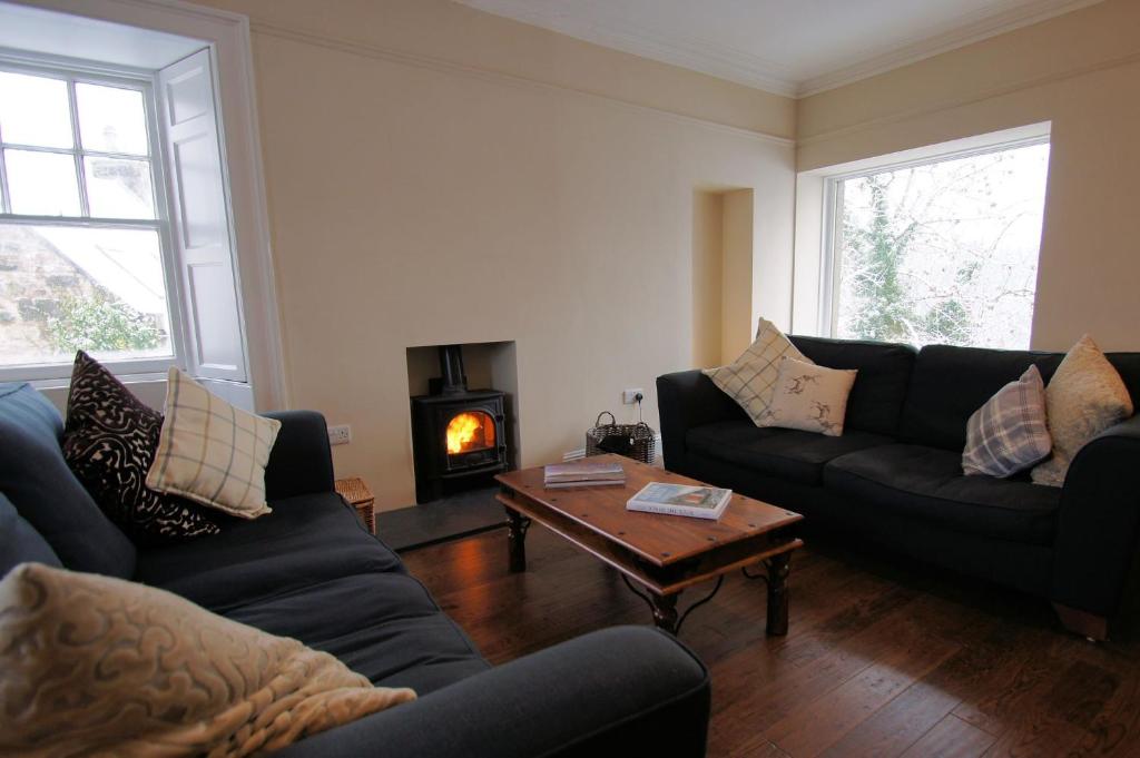 ein Wohnzimmer mit 2 Sofas und einem Couchtisch in der Unterkunft Comrie Old Schoolhouse in Comrie