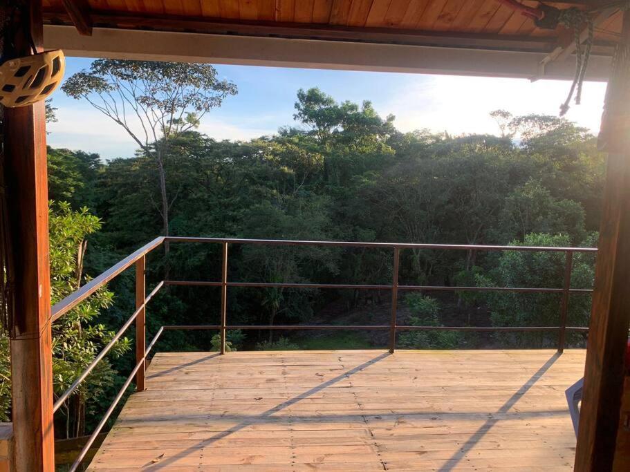 uma varanda com vista para uma floresta de árvores em Casa de campo ideal para descanso em Villavicencio