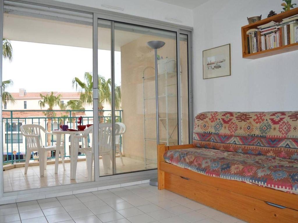 d'un salon avec un canapé et un balcon. dans l'établissement Appartement cosy au Port d'Argelès, 2 pièces/cabine, 6 couchages, proche mer, loggia, ménage inclus - FR-1-225-453, à Argelès-sur-Mer