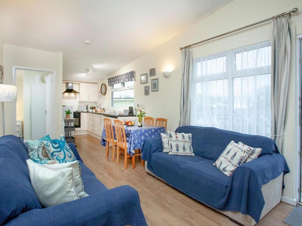 a living room with blue couches and a kitchen at Sunnydaze in Dartmouth