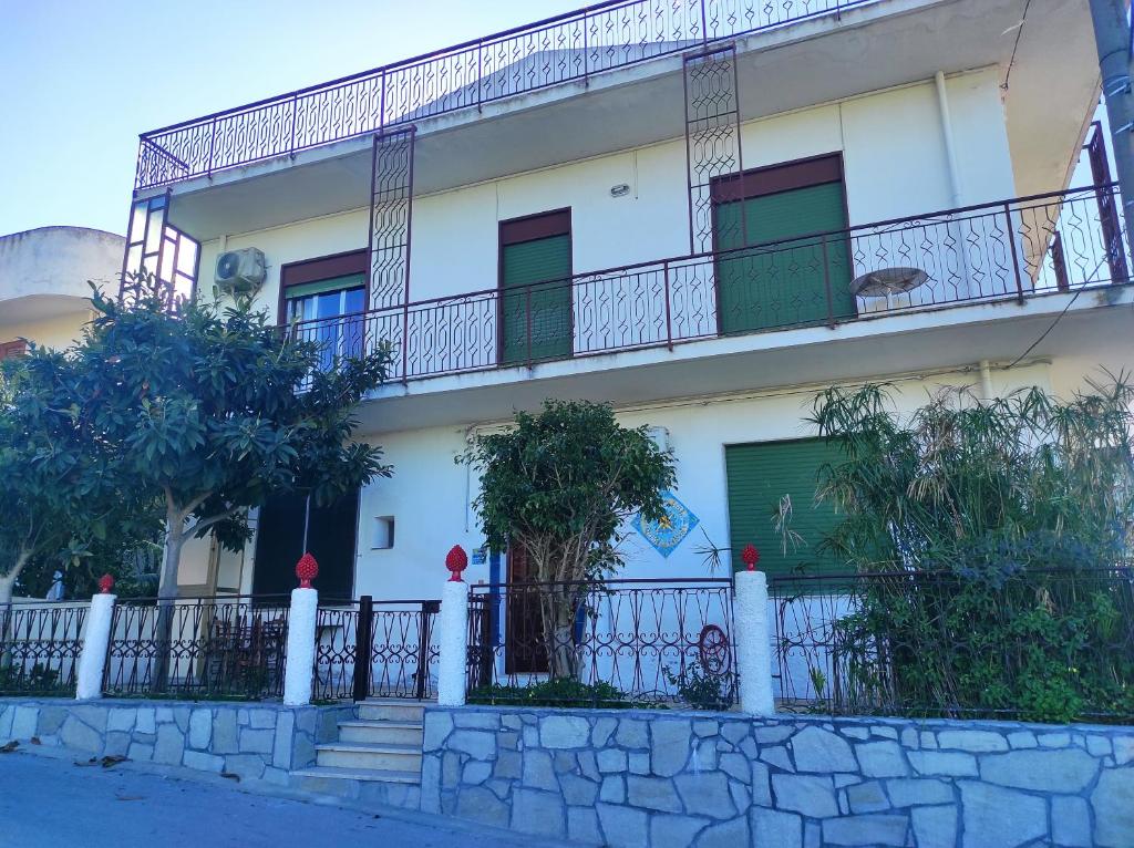 Edificio blanco con balcón y valla en MONGIOVE MARE Pìgna Rossa, en Patti