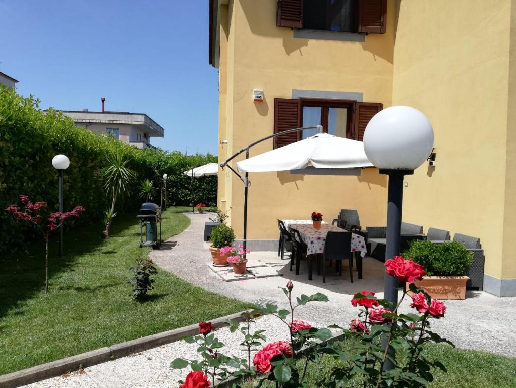 a patio with a table and an umbrella at Villa Rosa B&B Room Vesuvio in SantʼAntonio Abate