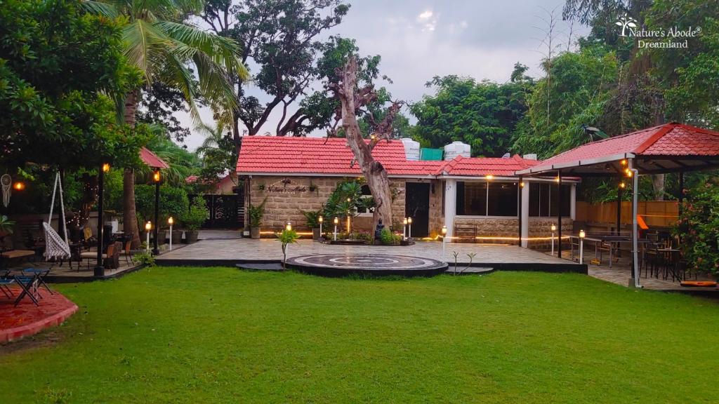 a house with a green lawn in front of it at Dreamland by Nature's Abode® Villas in Ahmedabad