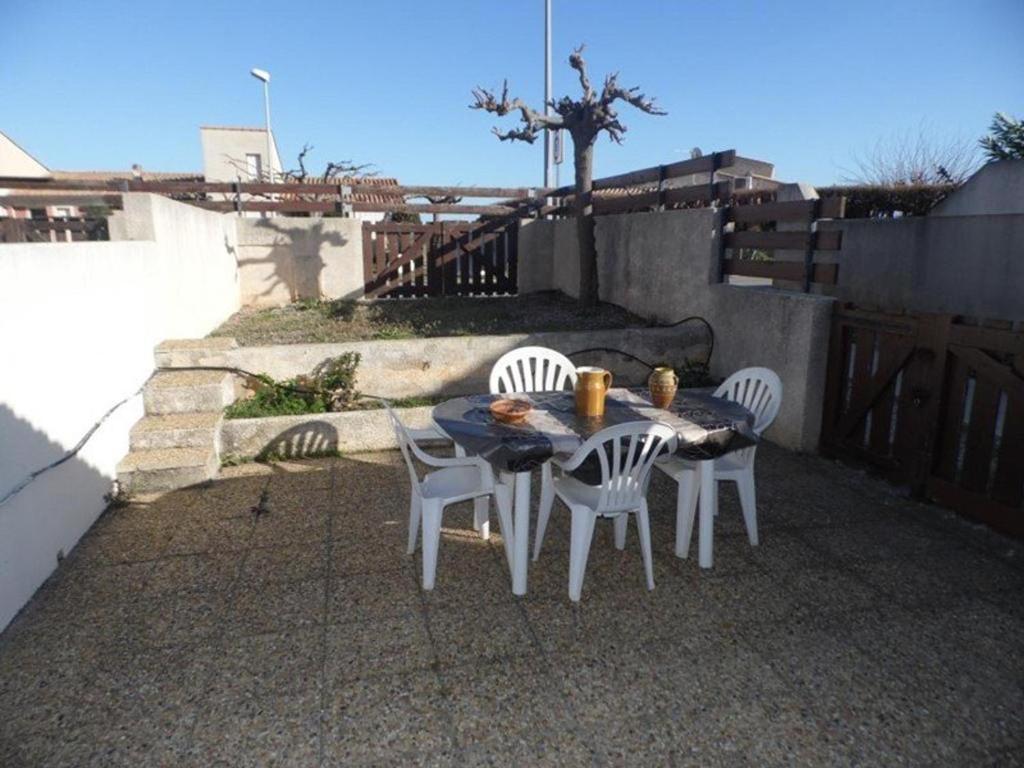 une table et des chaises assises sur une terrasse dans l'établissement Villa confortable 3 pièces, 6 pers, terrasse et parking privé - FR-1-326-411, à Marseillan