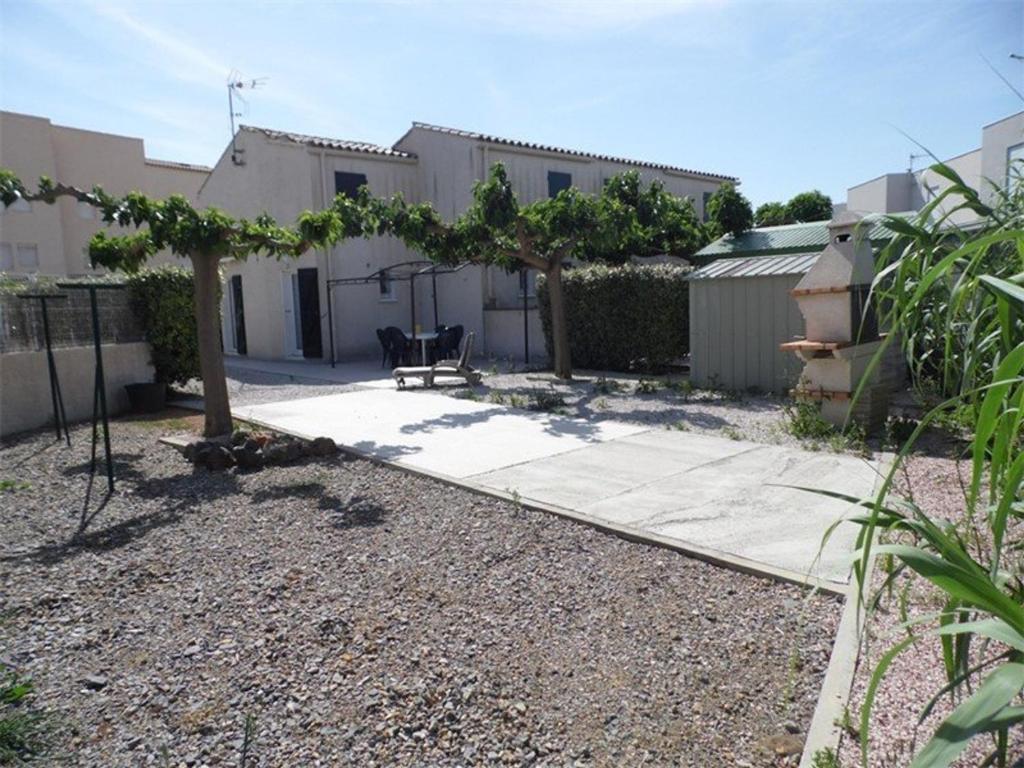 einen Hof mit einem Haus und einer Terrasse in der Unterkunft Maison Marseillan-Plage, 3 pièces, 5 personnes - FR-1-326-448 in Marseillan