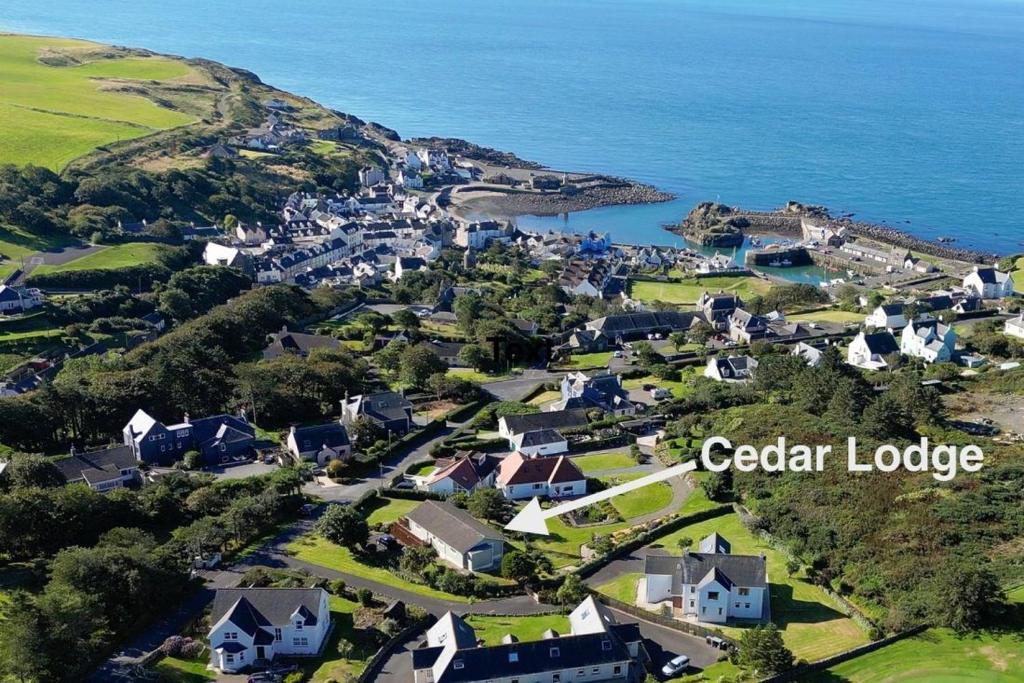 an aerial view of a village on a hill with the ocean at Cedar Lodge in Portpatrick