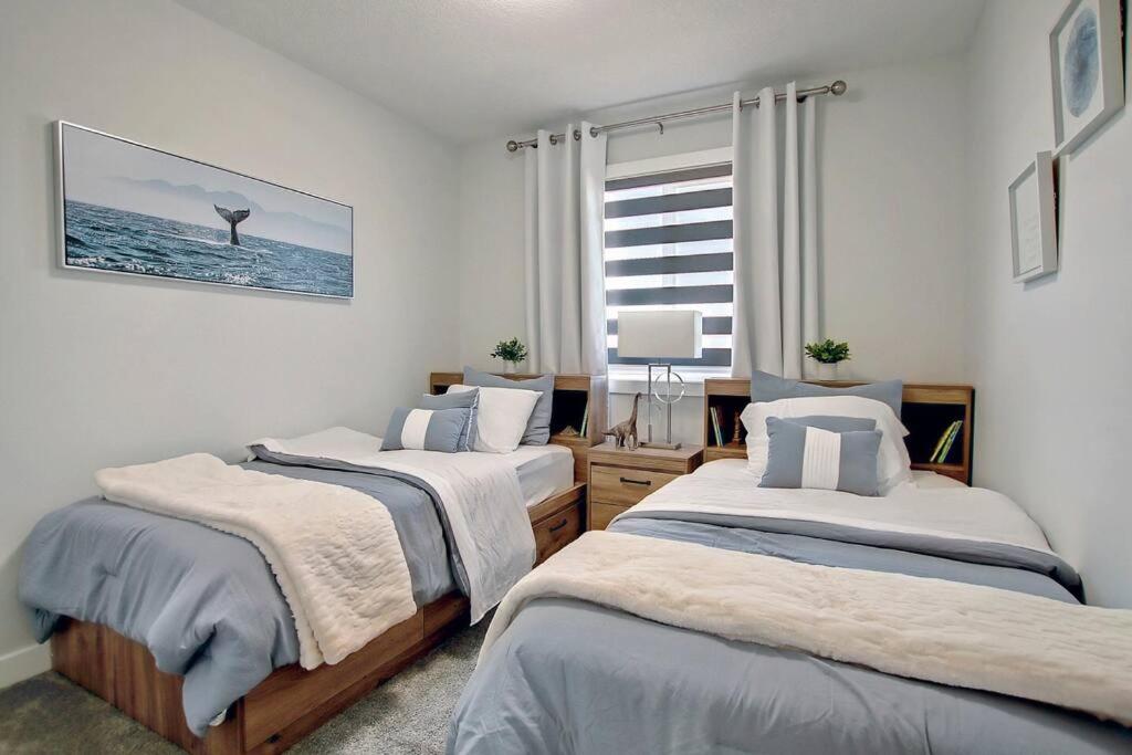 a bedroom with two beds and a window at Beautiful 3Bed-with AC-Close to Spruce Meadows & Mountains in Calgary