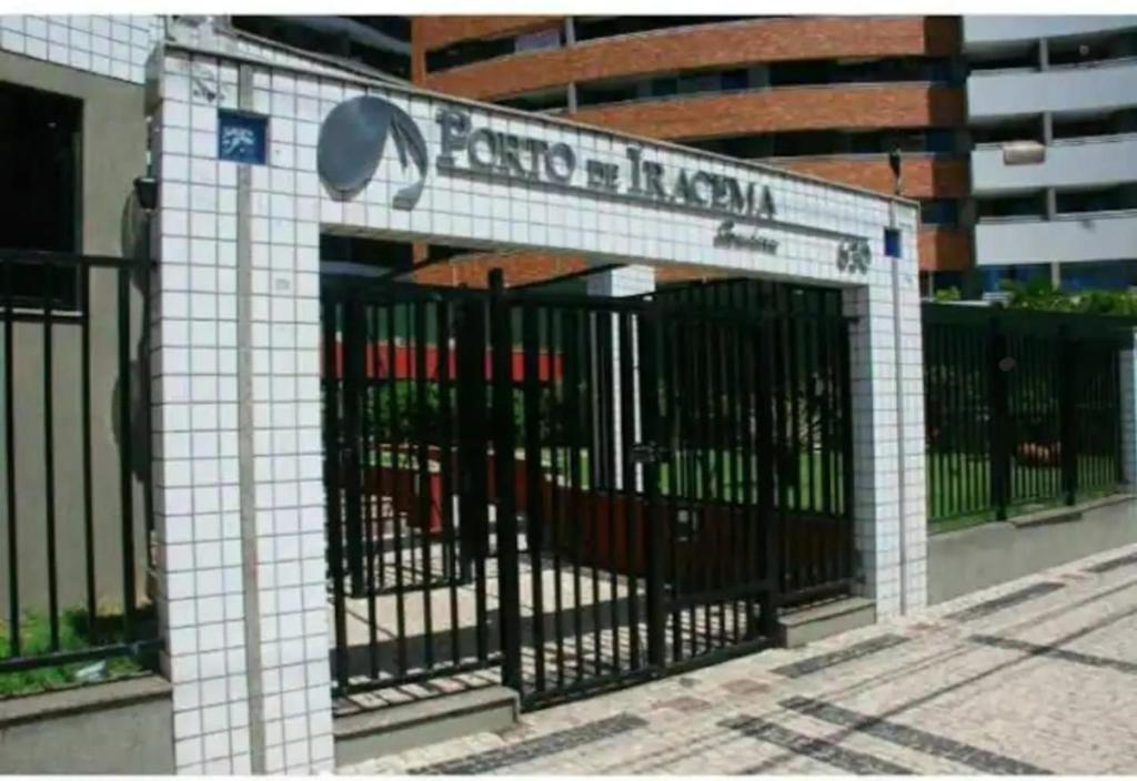 una puerta frente a un edificio con una señal en Condomínio Porto de Iracema, en Fortaleza