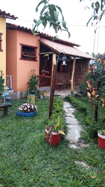 Casa dos Sonhos Hospedaria في Sêrro: منزل مع حديقة فيها نباتات في الفناء