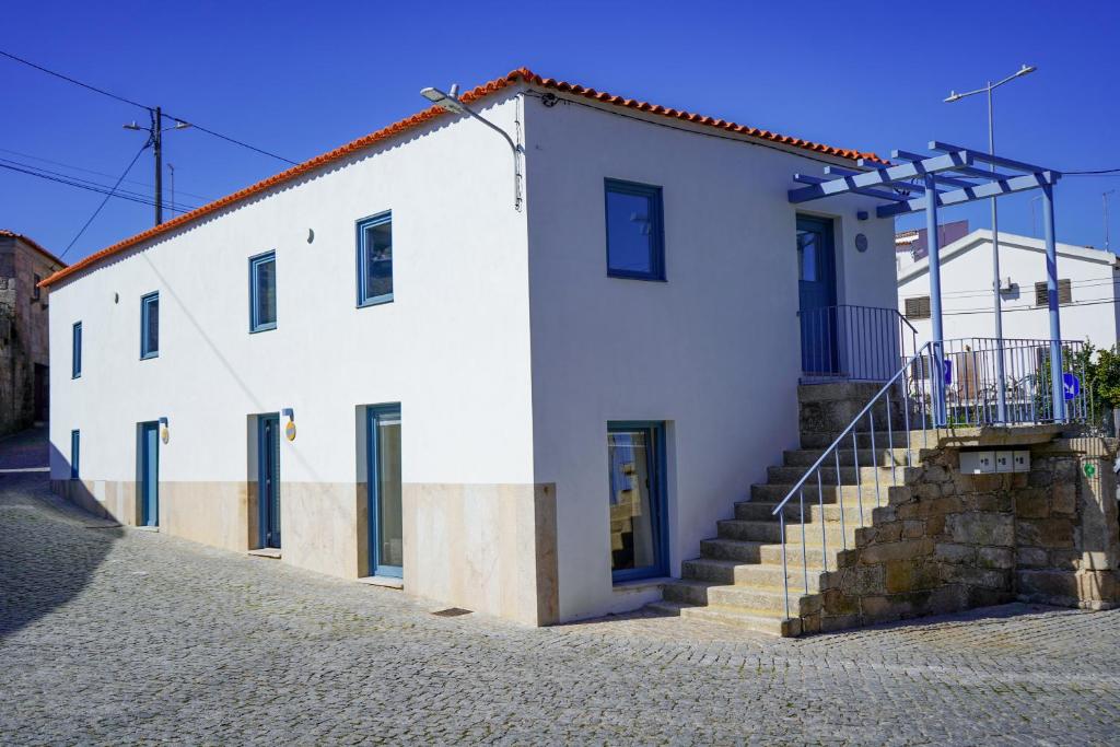 un edificio blanco con escaleras delante en Cellorico de Sabores, en Celorico da Beira