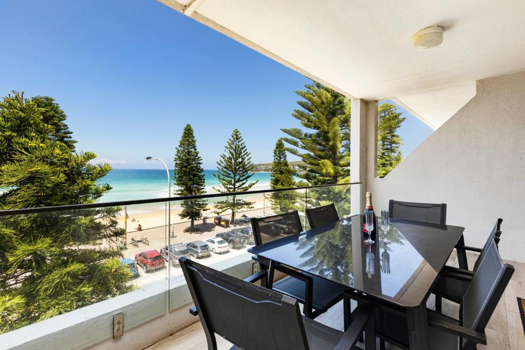 a dining room with a view of the ocean at Luxury Manly Beachfront Apartment in Sydney