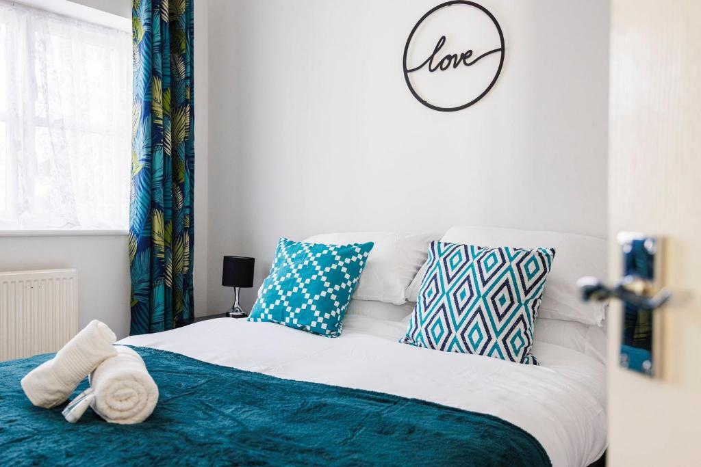 a bedroom with a bed with blue and white pillows at Ofrise Homes in Barking