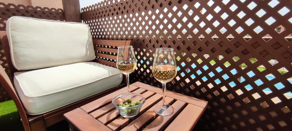 deux verres de vin sur une table avec une chaise dans l'établissement Ático de ensueño, El Toyo, Almería - Playas, Golf, Cabo de Gata, à Retamar